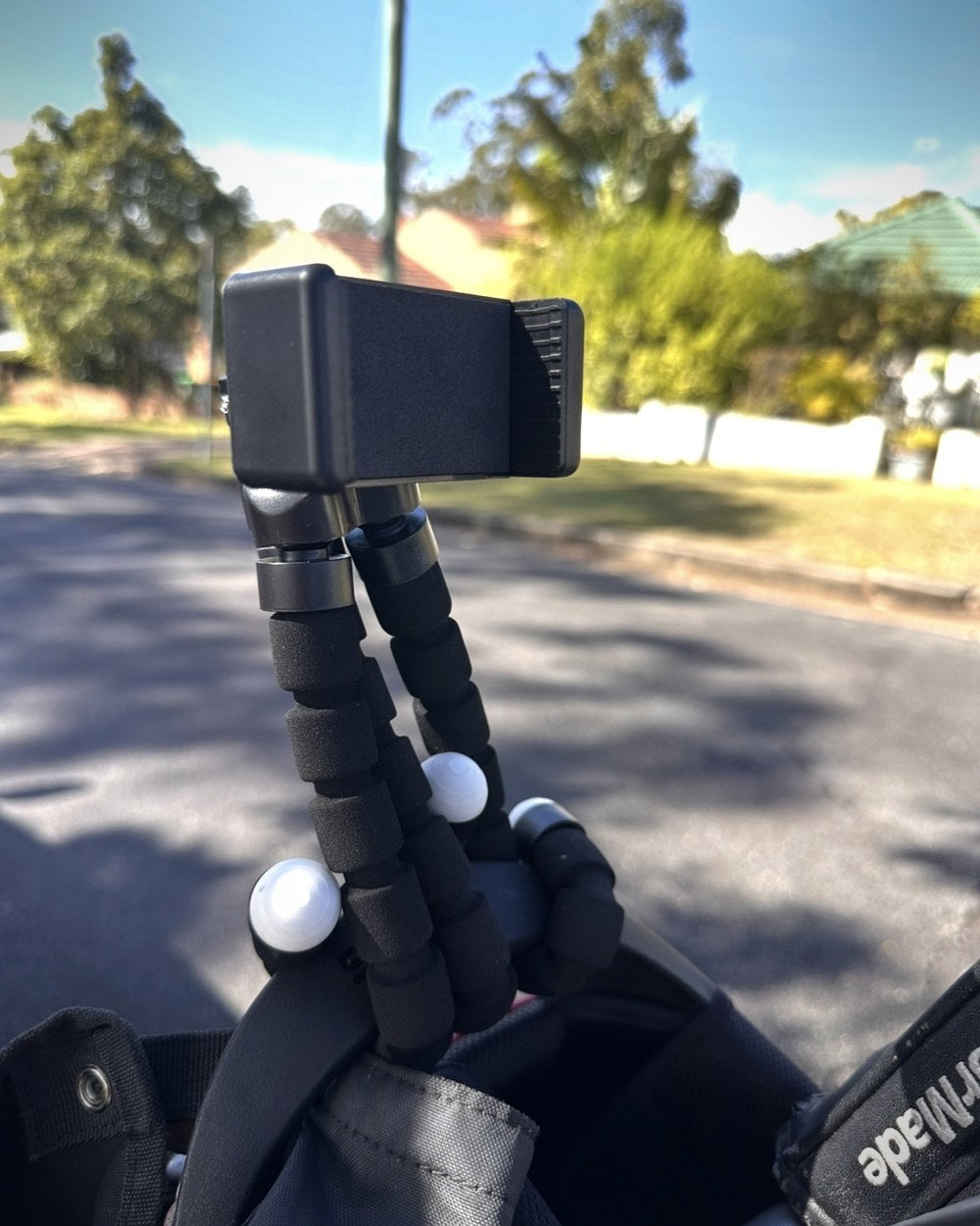 The Clippar mount clamped to the top of a golf bag, holding a phone
